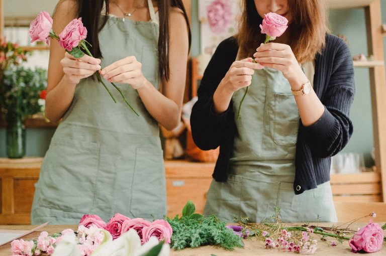 accueil Maison des fleurs photo de face de deux filles d'équipe maison des fleurs dans l'atelier prepare des bouquet